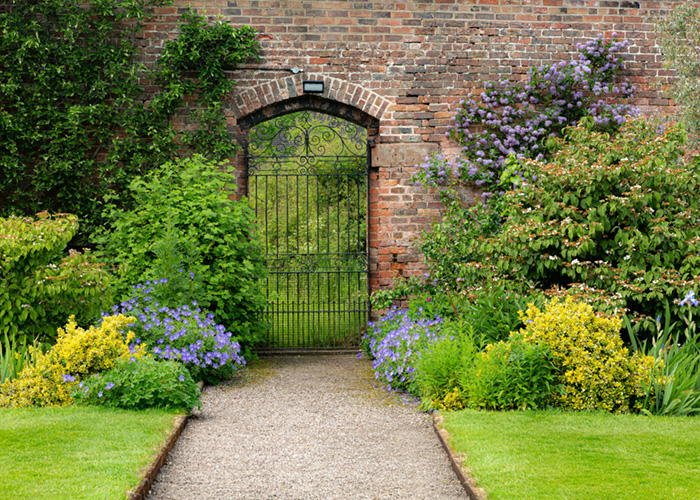 A stunning archway adorned with lush plantings from Loewen Greenhouses & Landscaping