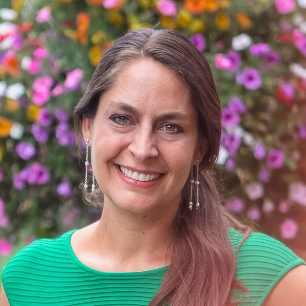 Sara Loewen, Manager, Designer, and Grower at Loewen Greenhouses & Landscaping, surrounded by thriving plants.